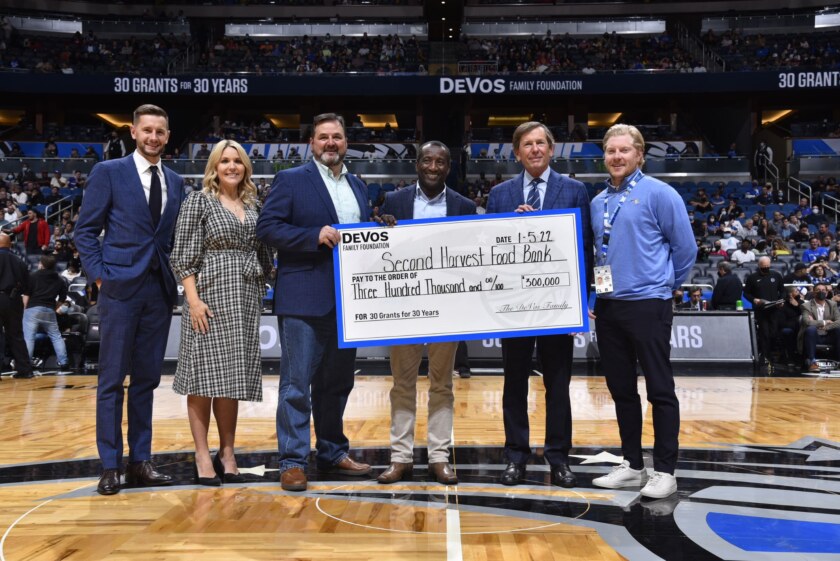 Ryan DeVos & Michelle DeVos, Dan DeVos and Jordan Richtsmeier present a check to Second Harvest Food Bank from the DeVos Family Foundation as part of the Orlando Magic 30 Grants for 30 Years Initiative.